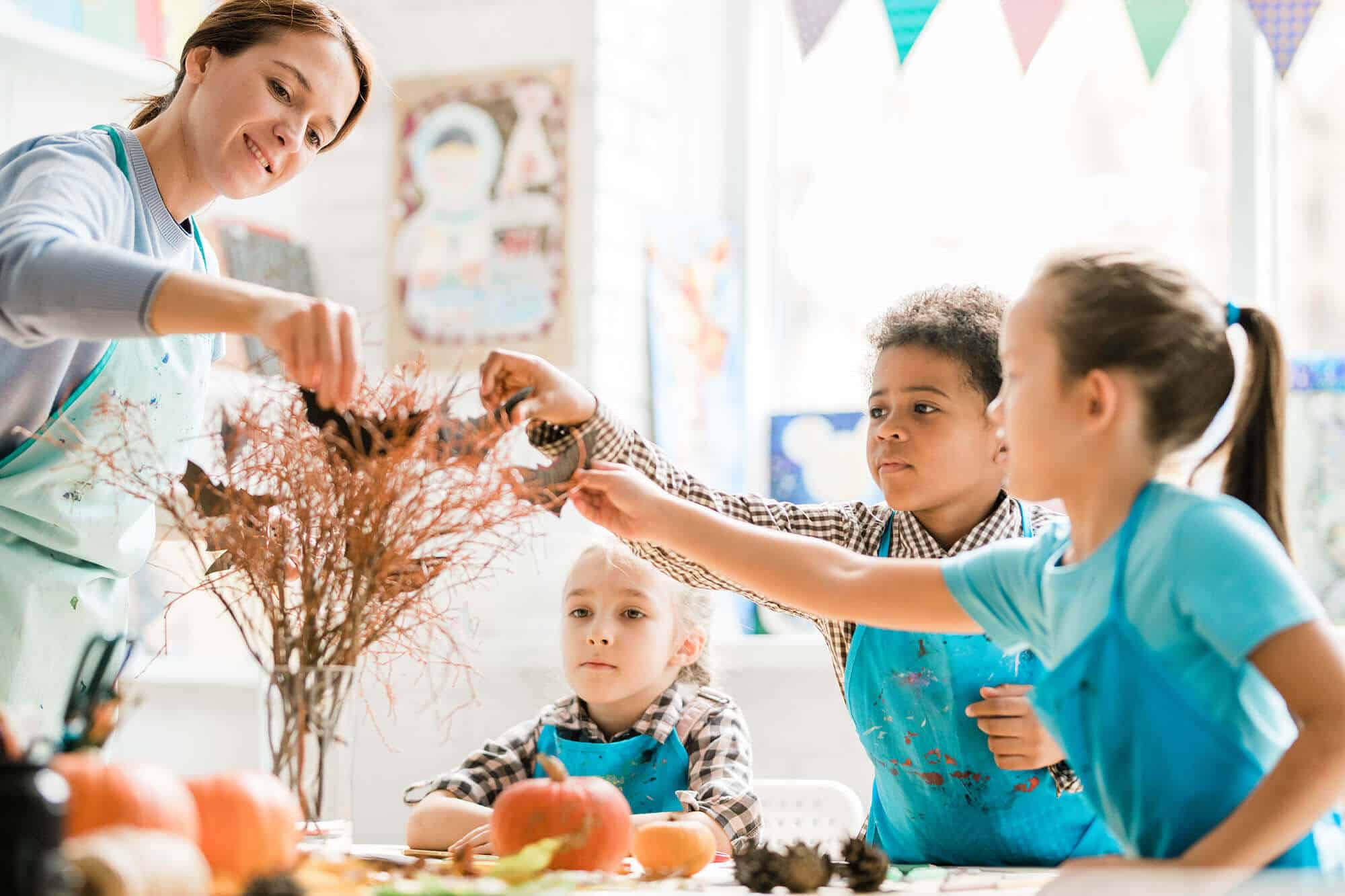 teacher-and-schoolkids-in-aprons-putting-handmade-2023-11-27-05-09-22-utc.jpg